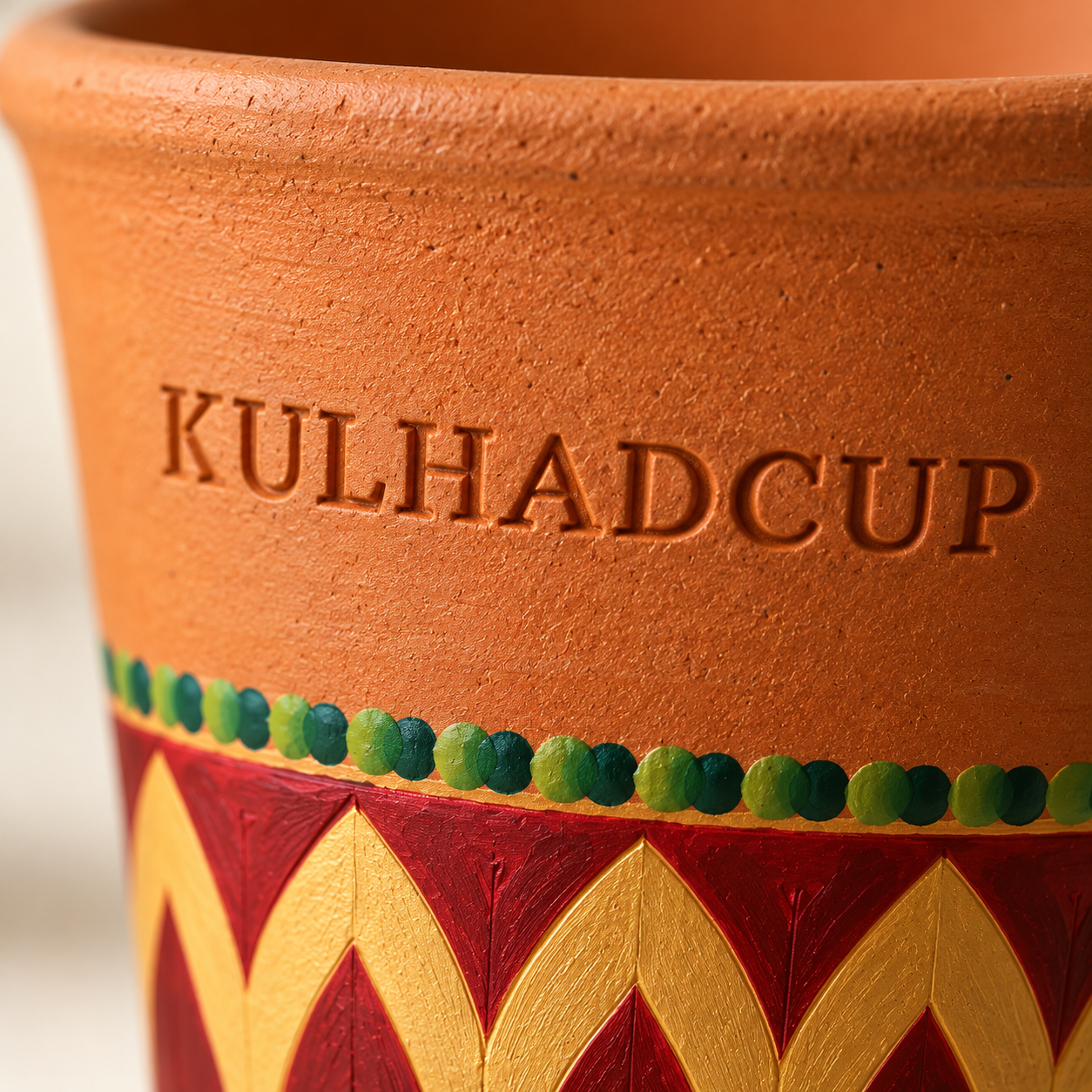 Macro view of engraving and hand-painted maroon gold petals on kulhad